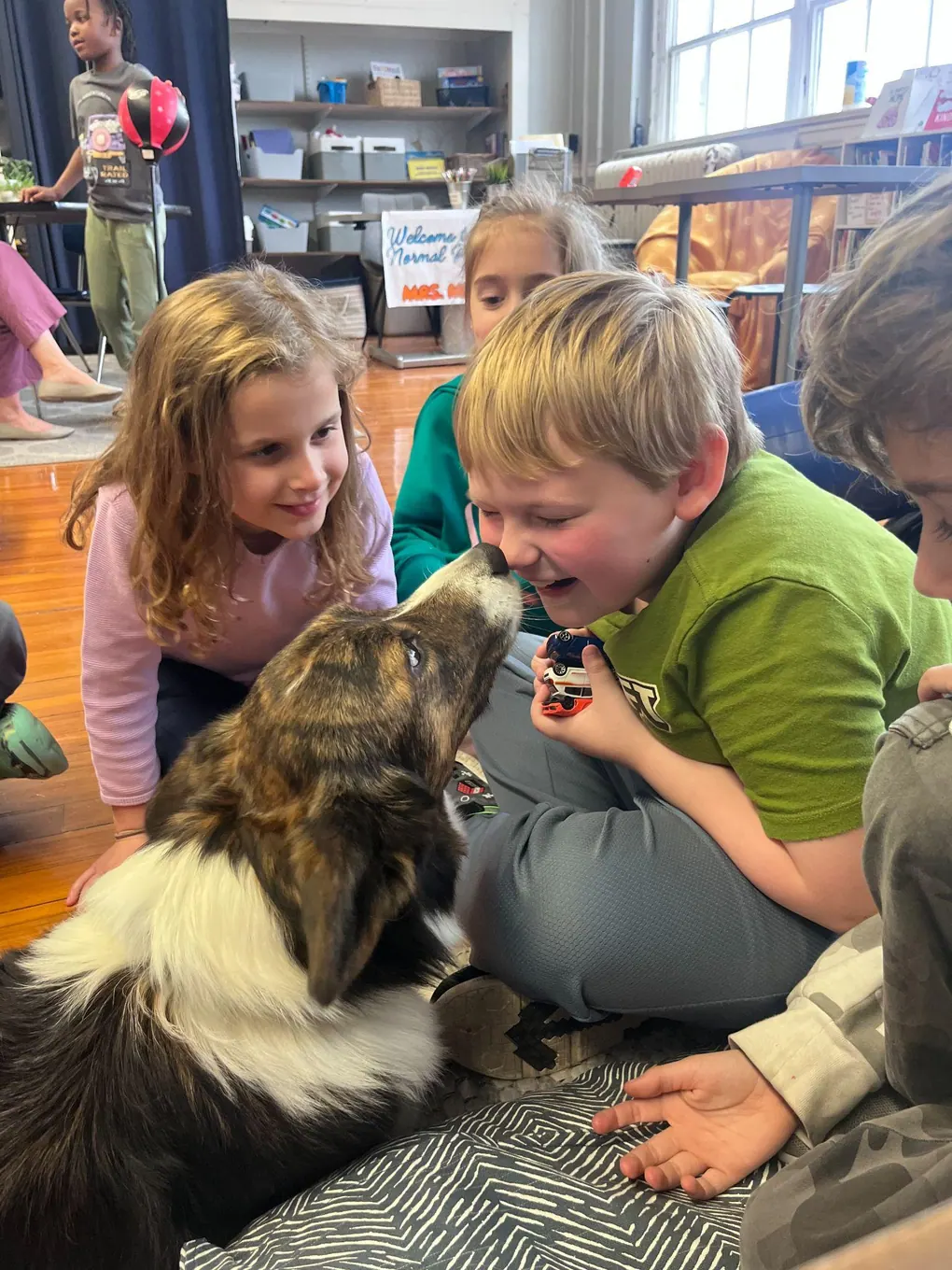 An adult and student interacting with a dog
